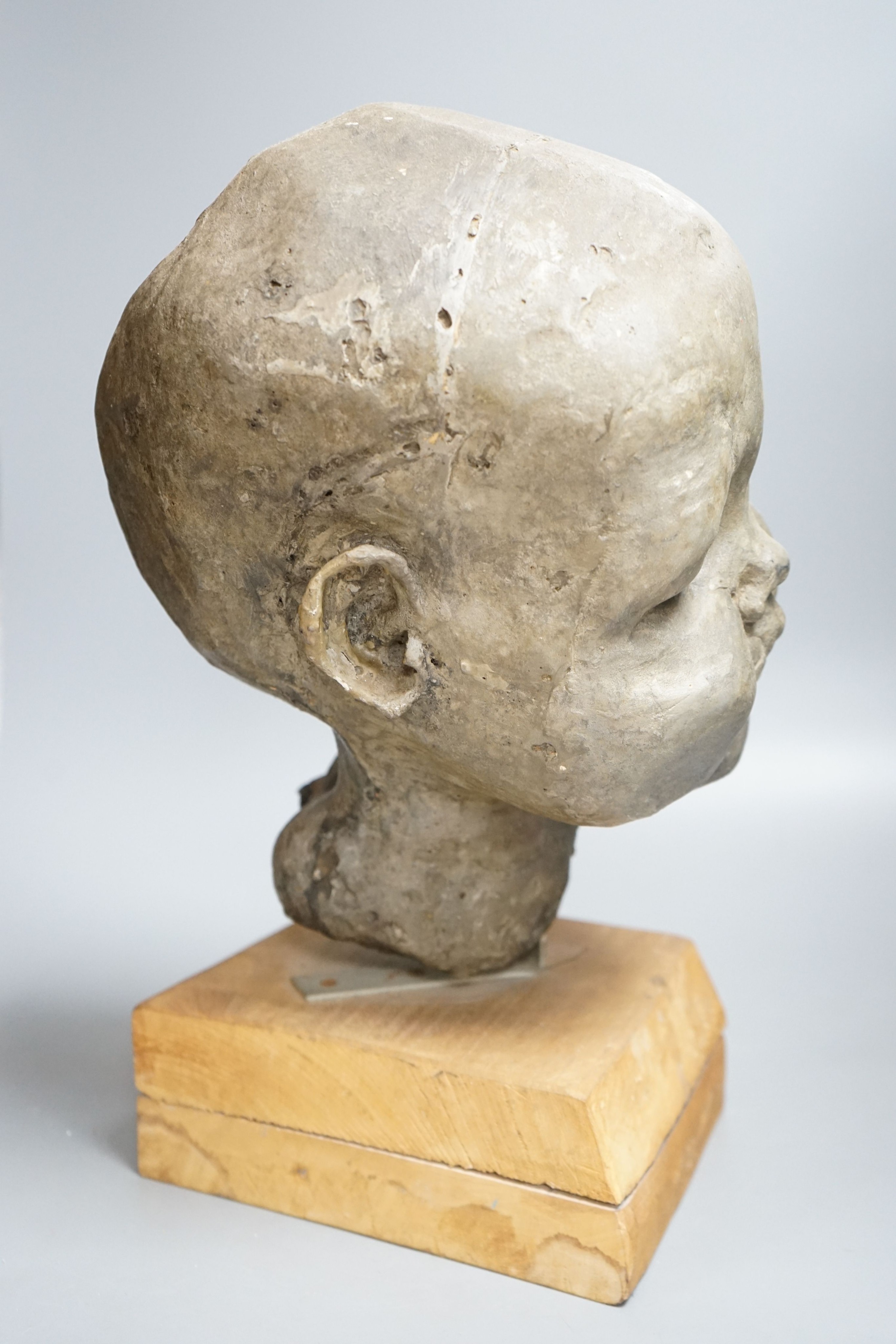 A composition sculpture of a child’s head 40 cm high including plinth